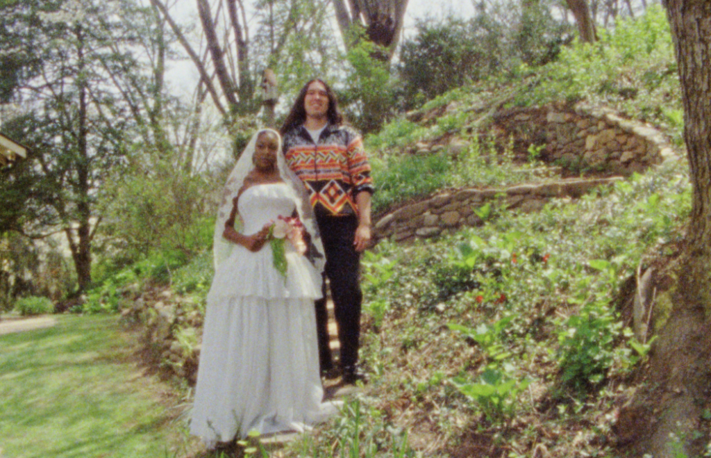 bride and groom posed together on garden backyard staircase made of stone, surrounded by greenery in Asheville on Super 8 film