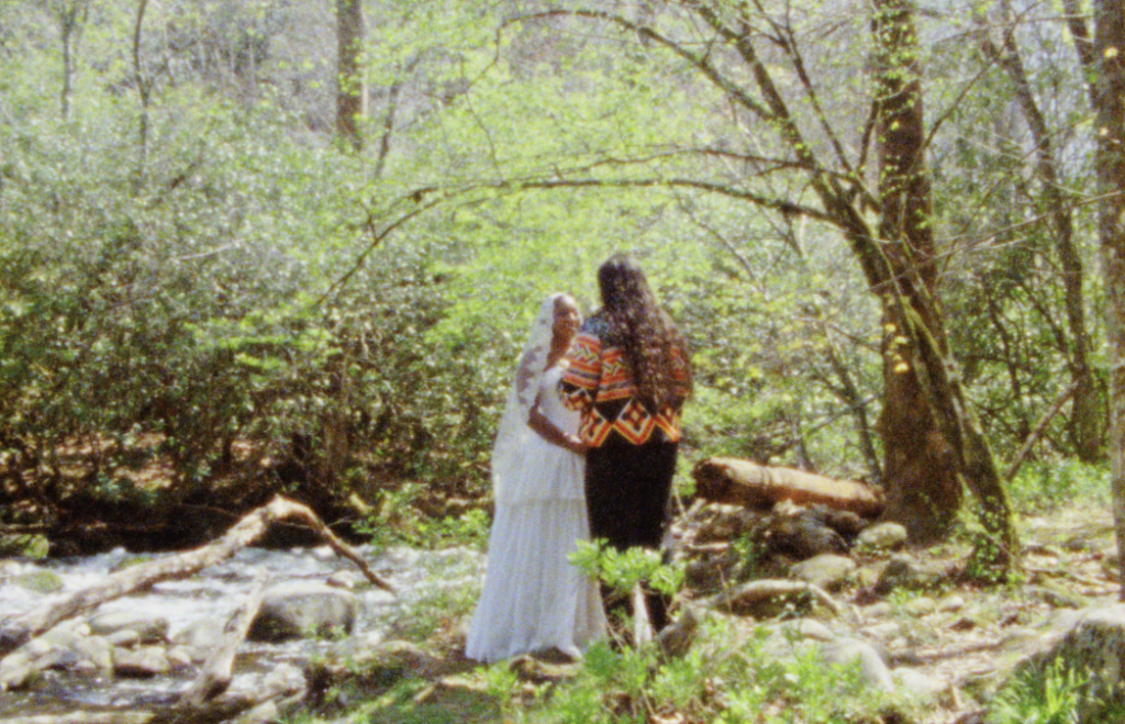 Bride and groom standing on an islet in the middle of a creek in the forest of the Great Smoky Mountains exchanging their vows for their elopement. Captured on Super 8mm film