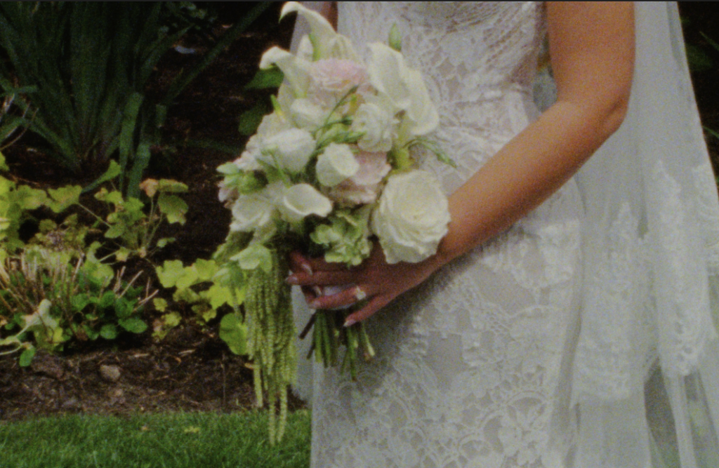 A Super 8mm still frame of the bride's floral bouquet full of green, pink, and white flowers