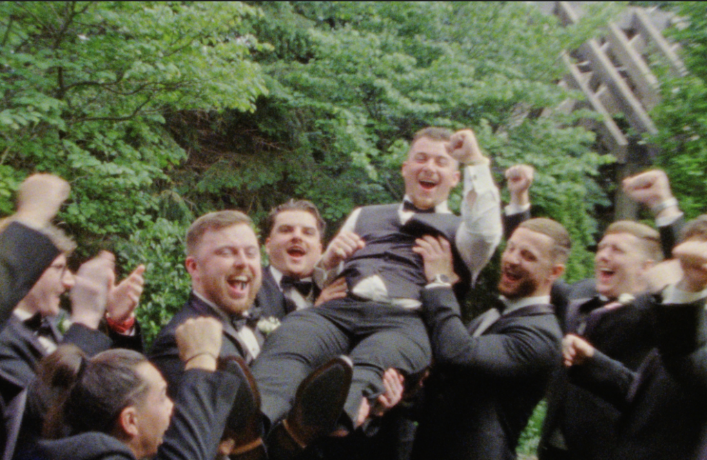 The groom being held up by his groomsmen, everyone cheering in triumph, in Plainfield, IL