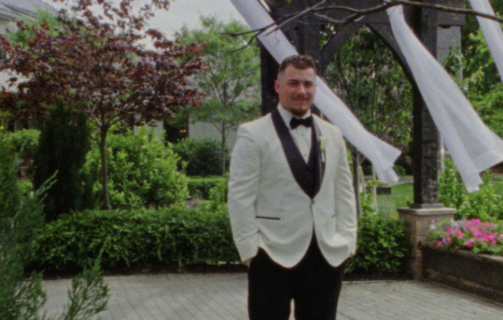 The groom posing for a portrait at the pavilion at the Farmhouse at Plainfield, awaiting the first look