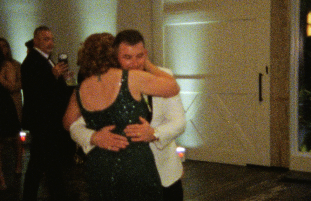 An up-close Super 8mm still frame of the groom dancing with his mother