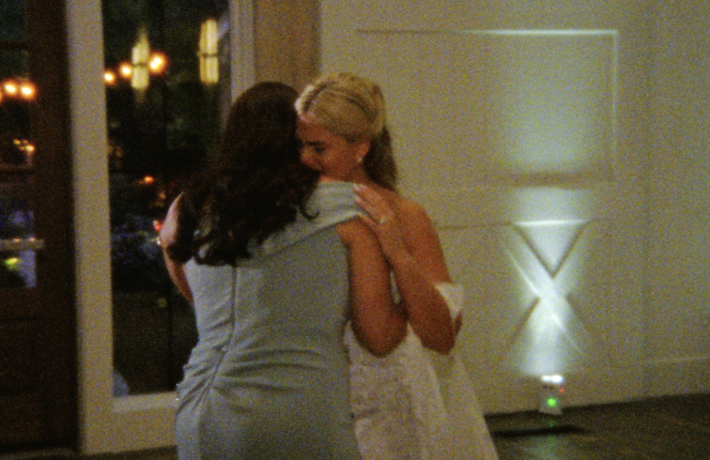 An up-close Super 8mm still frame of the Bride embracing her mother as they dance 
